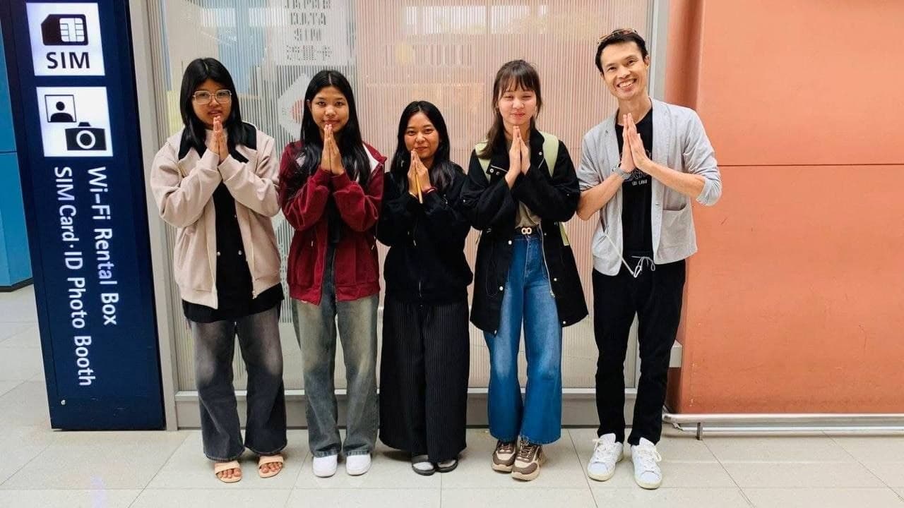 Students greeting their Japanese teacher with folded hands after arriving in Japan