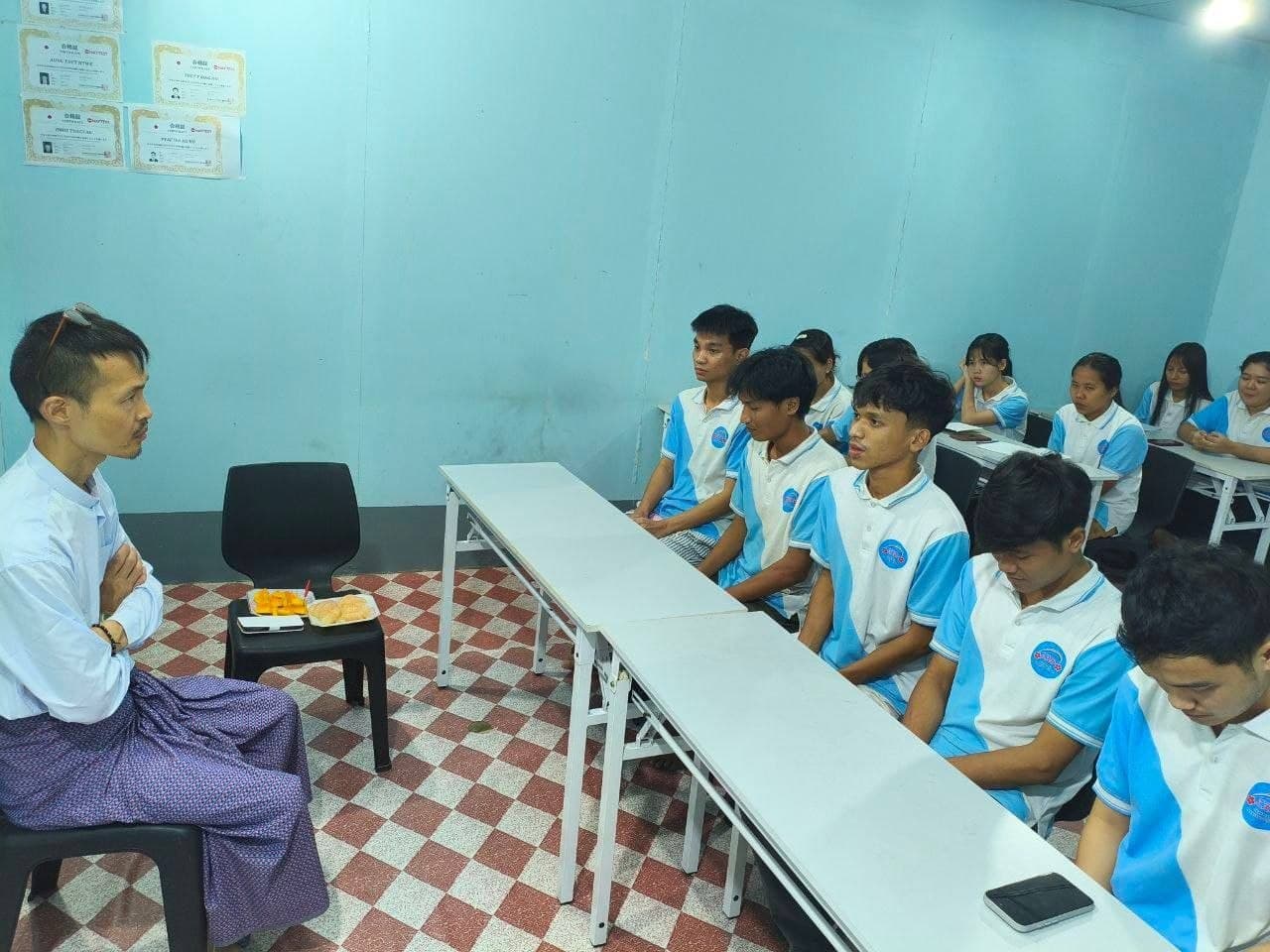 A Japanese teacher teaching a class of students in school polo shirts